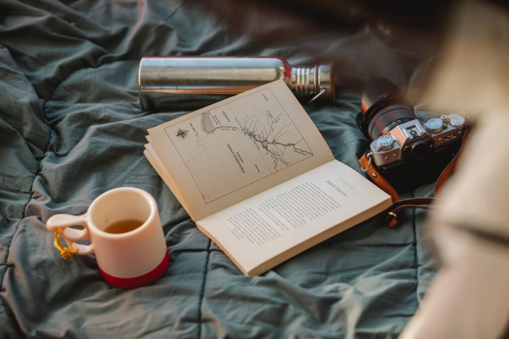 book with illustration and mug of tea on creased textile